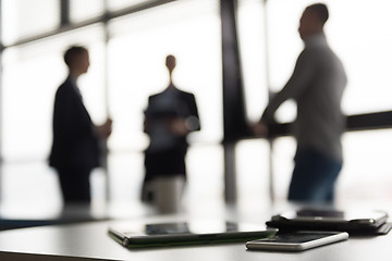 Image showing close up of tablet, business people on meeting in background