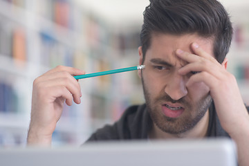 Image showing student in school library using laptop for research