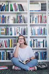 Image showing famale student reading book in library