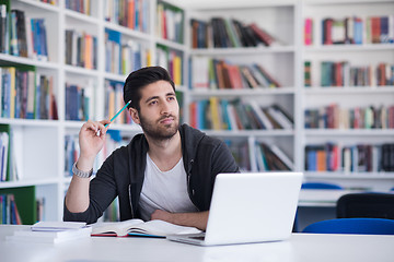 Image showing student in school library using laptop for research