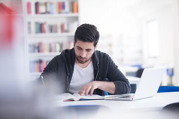 Image showing student in school library using laptop for research