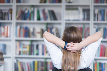 Image showing female student study in library, using tablet and searching for 