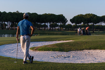 Image showing golfer from back at course looking to hole in distance