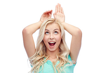 Image showing happy smiling young woman making bunny ears