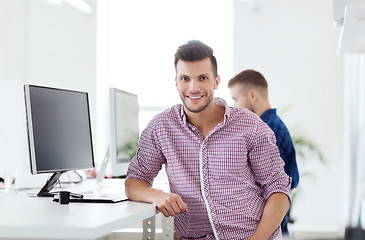 Image showing happy creative man with computer at office