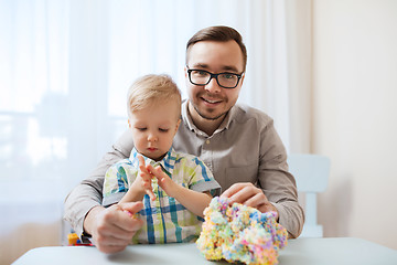 Image showing father and son playing with ball clay at home