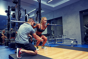 Image showing man and woman with bar flexing muscles in gym