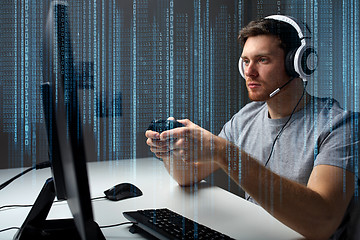 Image showing man in headset playing computer video game at home