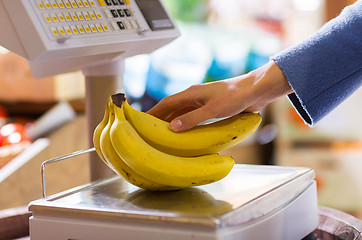 Image showing close up of woman hand with banana scales at shop