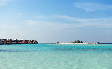 Image showing bungalow huts in sea water on exotic resort beach