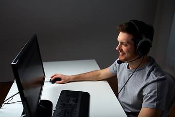 Image showing man in headset playing computer video game at home