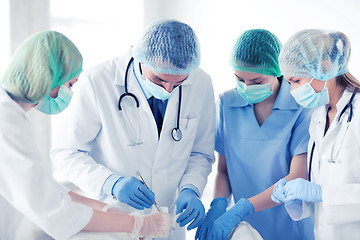 Image showing young group of doctors doing operation