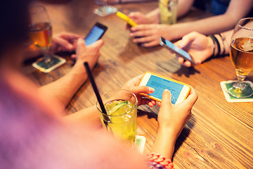 Image showing close up of hands with smartphones at restaurant