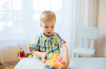 Image showing happy little baby boy with ball clay at home