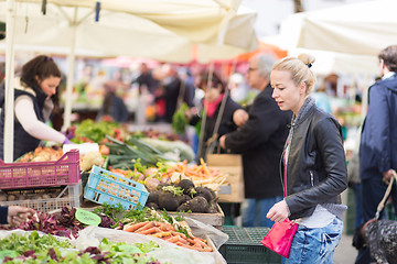 Image showing Woman buying vegetable at local food market. 