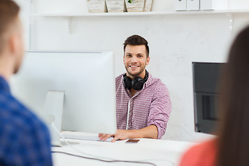 Image showing happy young man or student with computer at office