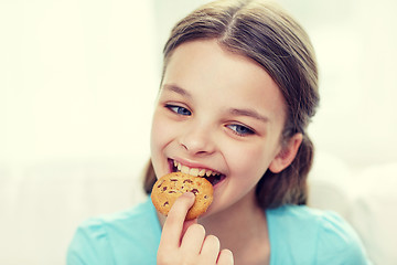 Image showing smiling little girl eating cookie or biscuit