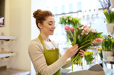 Image showing smiling florist woman making bunch at flower shop