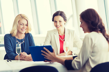 Image showing happy women with tablet pc at restaurant