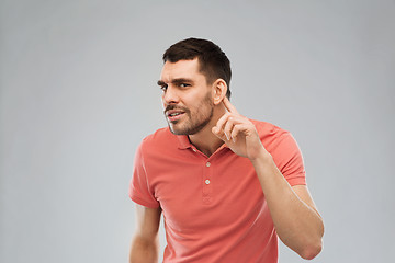 Image showing man having hearing problem listening to something