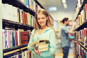 Image showing happy student girl or woman with book in library