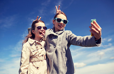 Image showing happy girls with smartphone taking selfie outdoors