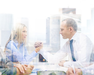 Image showing businesswoman and businessman arm wrestling