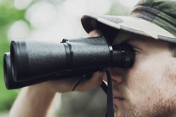 Image showing close up of soldier or hunter with binocular