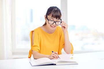 Image showing happy asian young woman student learning at home