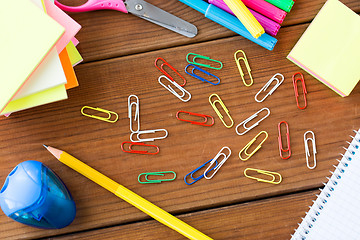 Image showing close up of clips, pens and stickers on wood