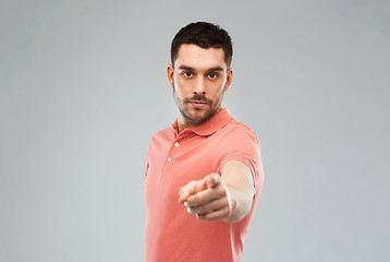 Image showing angry man pointing finger to you over gray