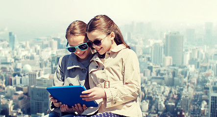 Image showing happy girls with tablet pc computer over city