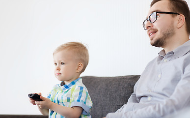 Image showing father and son with remote watching tv at home