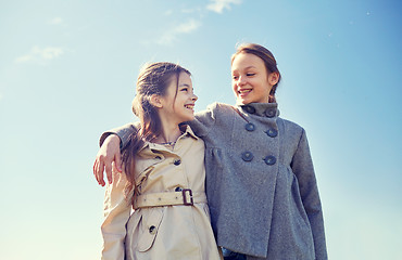 Image showing happy little girls hugging and talking outdoors