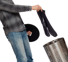 Image showing Young man putting dirty socks in a laundry basket