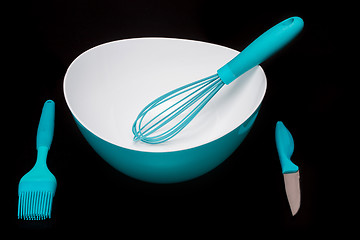 Image showing Green silicone pastry brush and soup plate isolated on black