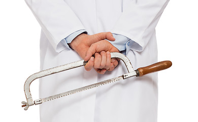 Image showing Crazy doctor is holding a big saw in his hands