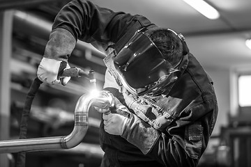 Image showing Industrial worker welding in metal factory.