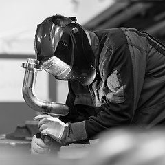 Image showing Industrial worker welding in metal factory.