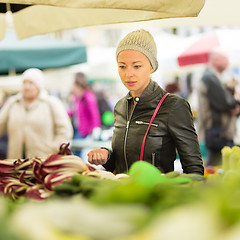 Image showing Woman buying vegetable at local food market. 