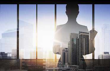Image showing silhouette of businesswoman with folder over city