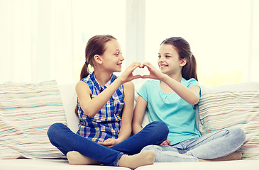 Image showing happy little girls showing heart shape hand sign