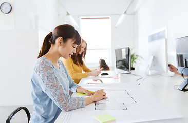 Image showing architect woman drawing on blueprint at office