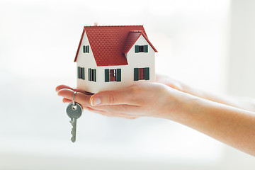 Image showing close up of hands holding house model and keys