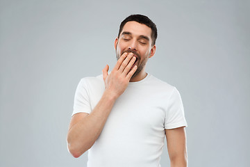 Image showing yawning man over gray background