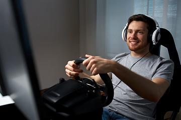 Image showing man playing car racing video game at home