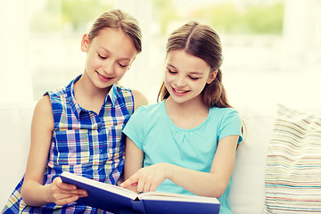 Image showing two happy girls reading book at home