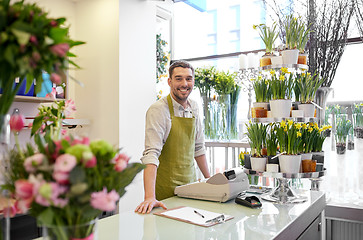 Image showing florist man with clipboard at flower shop counter