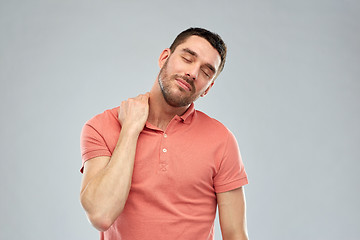 Image showing unhappy man suffering from neck pain