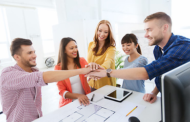 Image showing creative team holding hands together  at office